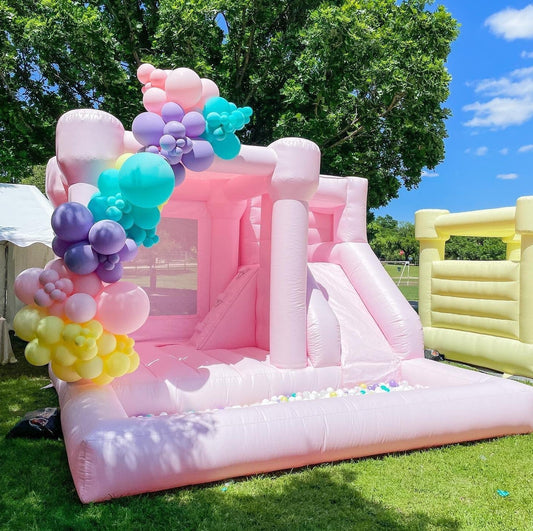 Pastel pink bounce castle commercial with slide and ball pit combo